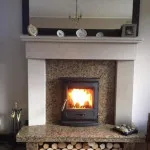 Multi fuel stove in marble inset and marble mantle with log storage